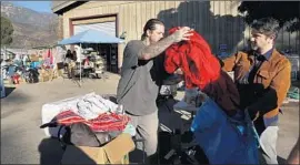  ??  ?? IN THE parking lot of an Ojai market, the grass-roots Upper Ojai Relief Center receives donations of clothing, food, toys and more for victims of the Thomas fire.