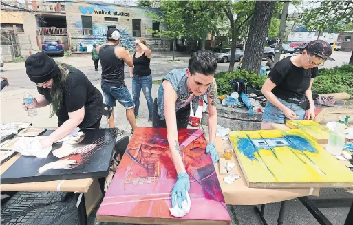  ?? STEVE RUSSELL PHOTOS/TORONTO STAR ?? Artists clean and try to salvage artwork Saturday outside Walnut Studios, a west-end building that housed 45 artists and suffered a fire May 19.