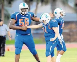  ?? GARY CURRERI/COURTESY ?? Hollywood Hills quarterbac­k Holly Neher celebrates with Malcolm King after throwing a touchdown pass on the first play from scrimmage against Pompano Beach on Friday.