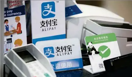  ?? BLOOMBERG PIC ?? Alipay and WeChat Pay’s logos are visible in stores and taxis in major cities around the world as the firms focus on helping travellers.