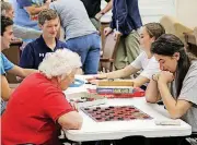  ?? [PHOTO PROVIDED] ?? A group of Casady School seniors play checkers with a resident at Lionwood Senior Living.