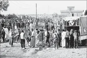  ?? MOADH AL-DULAIMI/GETTY-AFP ?? Displaced Iraqis line up for food and drinks at a safe zone Friday after government forces evacuated Fallujah amid their efforts to recapture the city from the Islamic State.