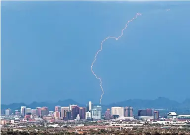  ?? MICHAEL CHOW/THE REPUBLIC ?? Lightning strikes behind downtown Phoenix on Wednesday.