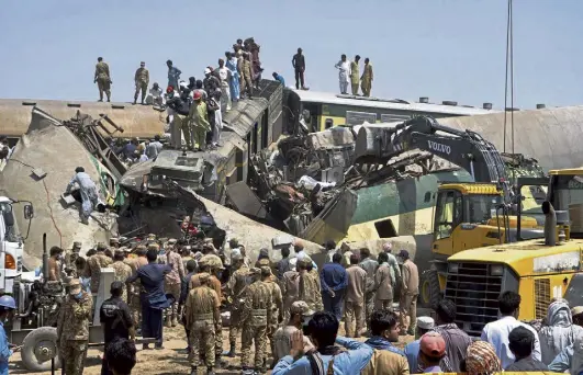  ?? Waleed Saddique, The Associated Press ?? Soldiers and volunteers work at the site of a train collision in the Ghotki district in southern Pakistan on Monday.