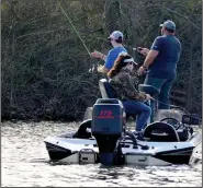  ?? (Arkansas Democrat-Gazette/Bryan Hendricks) ?? A family fishes for white bass Thursday at Lake Maumelle.