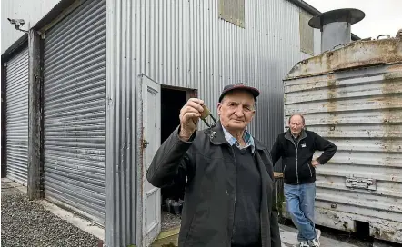  ?? JOHN BISSET/STUFF ?? Bill Noble (left) shows the broken lock which thieves used to raid the Pleasant Point Railway of four chainsaw. President Bryan Blanchard is in the background.