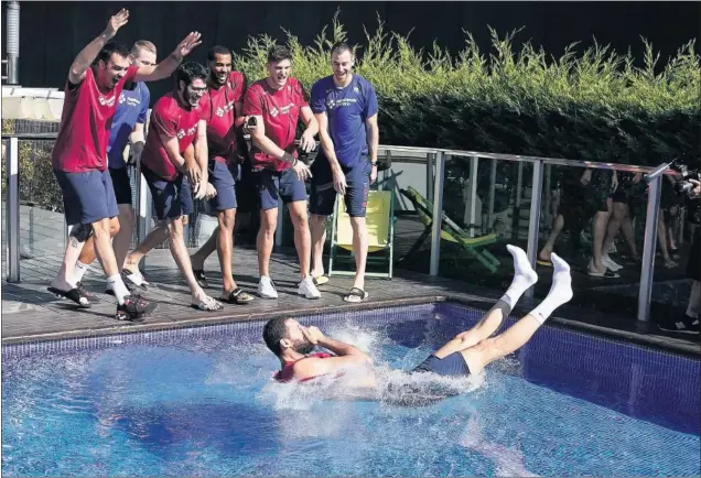  ??  ?? Los jugadores del Barça tiran a Nikola Mirotic a la piscina del hotel en el que se alojan en Valencia después de entregarle por sorpresa el premio de MVP de la Liga Endesa.