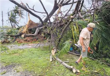  ?? GRACE GARCES BORDALLO AP ?? Andy Villagomez clears what remains of a tree that stood in his front yard before falling to Typhoon Mawar on Thursday in Mongmong-Toto-Maite, Guam. It was the strongest typhoon to hit the island since 2002.