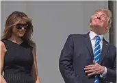 ?? — AFP ?? US President Donald Trump and First Lady Melania Trump look up at the partial solar eclipse from the balcony of the White House in Washington on Monday. The Great American Eclipse completed its journey across the United States.