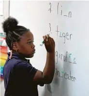  ??  ?? Kendall Johnson, 9, answers a spelling question. Students cheer each other for correct answers.