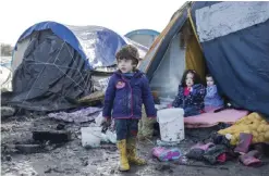  ??  ?? DUNKERQUE, France: Children of Kurdish migrants gather outside a tent at the Grande Synthe migrant camp. — AFP