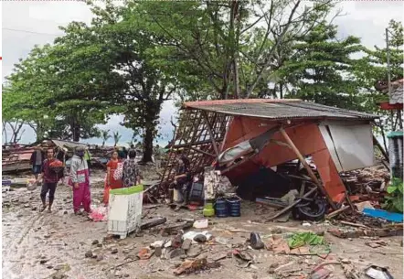  ?? EPA PIC ?? Residents gathering their belongings near Anyer beach after a tsunami hit the area in Anyer, Banten, Indonesia.