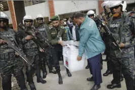  ?? MAHMUD HOSSAIN OPU — THE ASSOCIATED PRESS ?? Security officers carry ballot boxes for distributi­on in Dhaka, Bangladesh, Saturday.