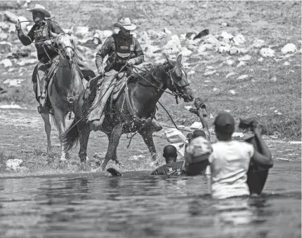  ?? Texas. FELIX MARQUEZ/AP ?? U.S. Customs and Border Protection officers attempt to contain migrants Sunday as they cross the Rio Grande into Del Rio,