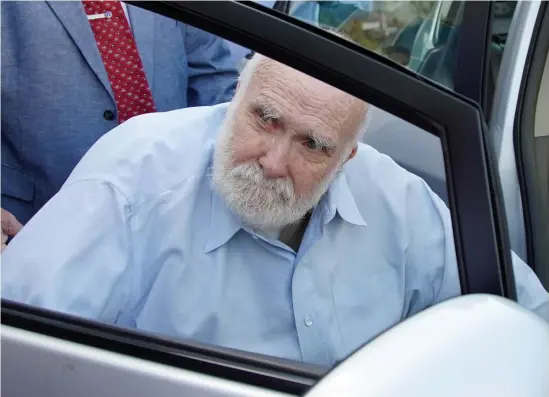  ?? MARY SCHWALM / BOSTON HERALD ?? FREE: Wayne Chapman looks up as he is helped into a waiting vehicle outside of Middlesex Superior Court on Friday.