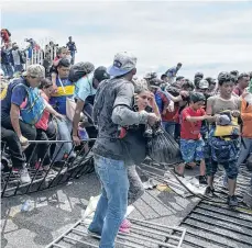  ?? /EFE ?? Los migrantes echaron abajo la valla y cruzaron ante la mirada de los agentes fronterizo­s.