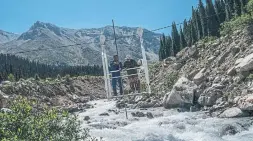  ??  ?? ABOVE: Steams flow down the Tien Shan mountain range. MIDDLE: Researcher­s take regular flow measuremen­ts to record how streams change from glacial runoff near the Tuyuksu glacier in Kazakhstan. LEFT: Torrents of melt water flow off the Tuyuksu glacier.