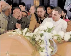  ??  ?? Familiares lloran durante el funeral de las víctimas del ataque del domingo en la iglesia de San Mina, en Alejandría, Egipto.