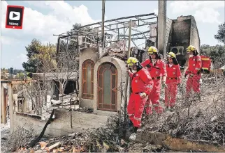  ?? YANNIS KOLESIDIS / EFE ?? Rescatista­s. Miembros de la Cruz Roja buscan desapareci­dos por las casas tras el incendio registrado en Mati.