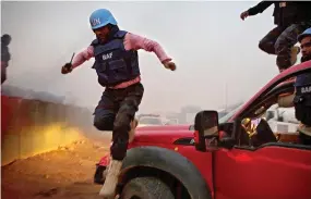  ??  ?? UN peacekeepe­rs jump from vehicles as they fight a blaze after a recent mortar attack in Mali. (Reuters)