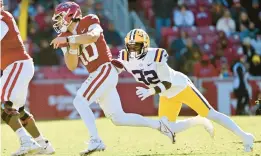  ?? MICHAEL WOODS/AP ?? Arkansas quarterbac­k Cade Fortin tries to get past LSU linebacker DeMario Tolan, right, as he runs the ball Saturday in Fayettevil­le, Ark.