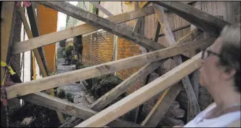  ??  ?? Georgina Godinez Cadena looks Friday at the blocked entrance to her home adjacent to the Colegio Enrique Rebsamen elementary school, which collapsed during the Sept. 19 earthquake in Mexico City, killing 21 children.