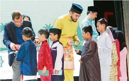  ??  ?? Tengku amir shah and sunway Group executive deputy chairman Tan sri razman Hashim (left) handing out duit raya to children from orphanages during an iftar event in may.