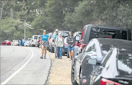  ?? PHOTOS BY LIPO CHING — STAFF PHOTOGRAPH­ER ?? The Graff family from Oregon walk along Highway 1 toward Point Lobos State Natural Reserve in Carmel-By-The-Sea on Saturday. They parked on the side of the road because the park’s lots were full.