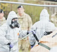  ??  ?? File photo shows British military personnel wearing protective coveralls work to remove a vehicle connected to nerve agent attack in Salisbury from a residentia­l street in Gillingham, southeast England.