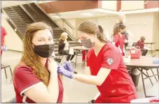  ?? LYNN KUTTER ENTERPRISE-LEADER ?? Keith-Ann Thornburg, Lincoln band director, receives the Moderna covid-19 vaccine on Thursday during the district’s vaccinatio­n clinic at Lincoln High School. Julia Lewis, a nursing student from the University of Arkansas, is one of many nursing students who helped with the clinic.