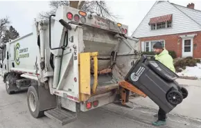  ?? MICHAEL SEARS / MILWAUKEE JOURNAL SENTINEL ?? Compost Crusader driver Robert Johnson makes a pickup in a residentia­l area of Wauwatosa, emptying compost containers into his truck. Compost Crusader, a St. Francis-based composting company, is hoping to be a part of the DNC’s composting efforts. The company works with several municipali­ties and businesses, diverting 2.8 million pounds of waste in 2019.