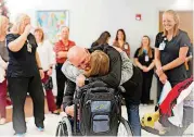  ??  ?? Kitterman hugs Dr. David Owens, respirator­y therapy director at Children’s Center Rehabilita­tion Hospital in Bethany, on Tuesday as staff and friends celebrate her discharge.