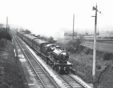  ??  ?? Fowler LMS Compound No 929 makes the most of the level section of track between Kildwick and Cononley as it works a Leeds and Bradford excursion to Morecambe on Friday, 9 May 1930. The May 1927-built 4-4-0 is working the usual mix of coaching stock used for excursion work, ranging from clerestory coaches to low-roof pre-grouping vehicles and early LMS stock. As was generally the case at this time, No 929 looks resplenden­t, the Holbeck Compounds being kept in fine external and mechanical condition. Judging from the exhaust, No 929 is being worked in compoundin­g mode and the fireman will probably be firing with the ‘little and often’ technique to keep the fire bright.