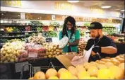  ?? Robert Gauthier Los Angeles Times ?? THE CUTS include 10 workers who recently formed a union. Above, Matthew Otsuka helps Instacart shopper Kara Pete with fruit at Whole Foods in 2014.