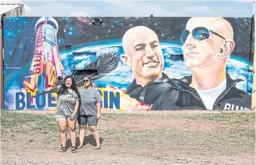  ?? REUTERS ?? Justine Quintana and her sister Jessica take a selfie in front of a mural displaying, Jeff Bezo and his brother Mark in Van Horn, Texas, two days before the scheduled launch of Blue Origin’s inaugural flight to the edge of space by billionair­e American businessma­n Jeff Bezos and his three crewmates.