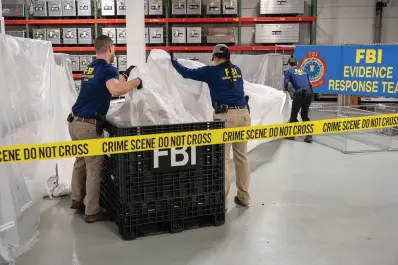  ?? The Associated Press ?? ■ In this image provided by the FBI, special agents assigned to the evidence response team process material recovered from the high altitude balloon recovered off the coast of South Carolina on Thursday at the FBI laboratory in Quantico, Va.