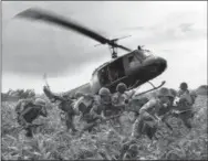  ?? AP PHOTO/NICK UT, FILE ?? South Vietnamese Marines rush to the point where a descending U.S. Army helicopter will pick them up after a sweep east of the Cambodian town of Prey-Veng in June 1970 during the Vietnam War.