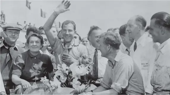  ??  ?? Sir Stirling Moss (waving) after a win with Jaguar in the 1953 12-hour sports car race at Rheims, France, by covering 1,274 miles at an average speed of 105.5 miles per hour. Picture PA Wire
