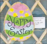 ?? (NWA Democrat-Gazette/Susan Holland) ?? A colorful egg featuring both stripes and polka dots adorns the front door at The Patio barber and tanning salon, along with a note from the owner that the business is temporaril­y closed because of covid-19 but “hope to be open again soon!”