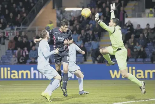  ??  ?? Brian Graham heads past Queen of the South keeper Deniz Mehmet to complete Ross County’s 4-0 victory.