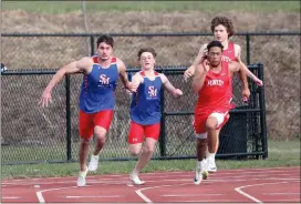  ?? Photo by Becky Polaski ?? Dutchman Johnny Bandy takes the handoff from teammate TJ Singer during the boys’ 4x100 meter relay.