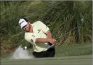  ?? CHRIS O’MEARA — THE ASSOCIATED PRESS ?? J. B. Holmes hits from the sand onto the 14th green during the third round of The Players Championsh­ip Saturday in Ponte Vedra Beach, Fla.