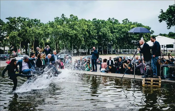  ?? LLIBERT TEIXIDÓ ?? A la de una, dos y tres. Los candidatos, siguiendo las instruccio­nes de Pedro Madueño, dan una patada al agua en la sesión fotográfic­a en el pabellón Mies van der Rohe