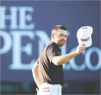  ?? OISIN KENIRY/GETTY IMAGES ?? Louis Oosthuizen waves to the crowd during Friday's action at the Open, where he leads the field by two strokes. The South African's 36-hole score of 129 set a new Open Championsh­ip record.