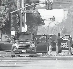  ?? JAE C. HONG, AP ?? Investigat­ors gather Thursday around an SUV a day after the shootout that killed terrorists in San Bernardino, Calif.