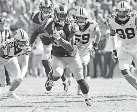  ?? Wally Skalij Los Angeles Times ?? TODD GURLEY of the Rams breaks away from Carolina cornerback James Bradberry (24) and linebacker­s Luke Kuechly (59) and Marquis Haynes (98) in the fourth quarter to pick up some of his game-high 97 yards rushing, but it wasn’t one of his dominant performanc­es.