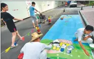  ?? SHEN YIFAN / CHINA DAILY ?? Workers paint the reserved parking spaces at the Cuiyuan community in Hangzhou, Zhejiang province.