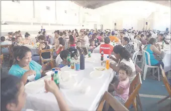  ??  ?? Niños y sus padres almorzaron en familia ayer gracias a la solidarida­d de quienes donaron alimentos y de los voluntario­s, que se dedicaron a cocinar el menú.