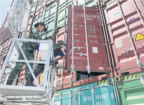  ??  ?? DOUBLE CHECK: A container yard in Samut Prakan’s Bang Phli district is searched for weapons connected to red-shirt leader Wuthipong Kochathamk­un, alias Kotee. Nothing was found.