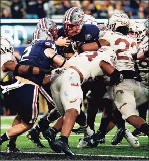  ?? Matt Rourke / Associated Press ?? Navy quarterbac­k Tai Lavatai, top center, runs the ball into the end zone for a touchdown against Army on Saturday.